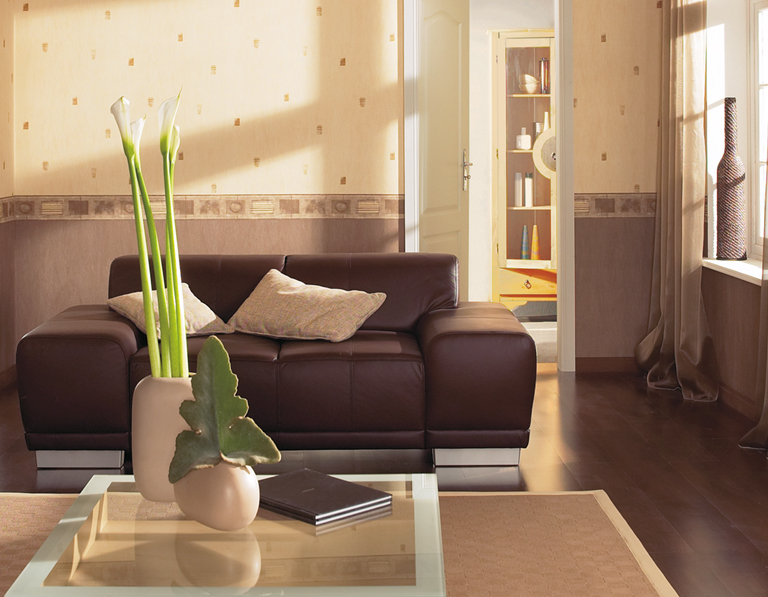 Das Bild zeigt ein Wohnzimmer in braun-beiger Optik mit einem braunen Ledersofa